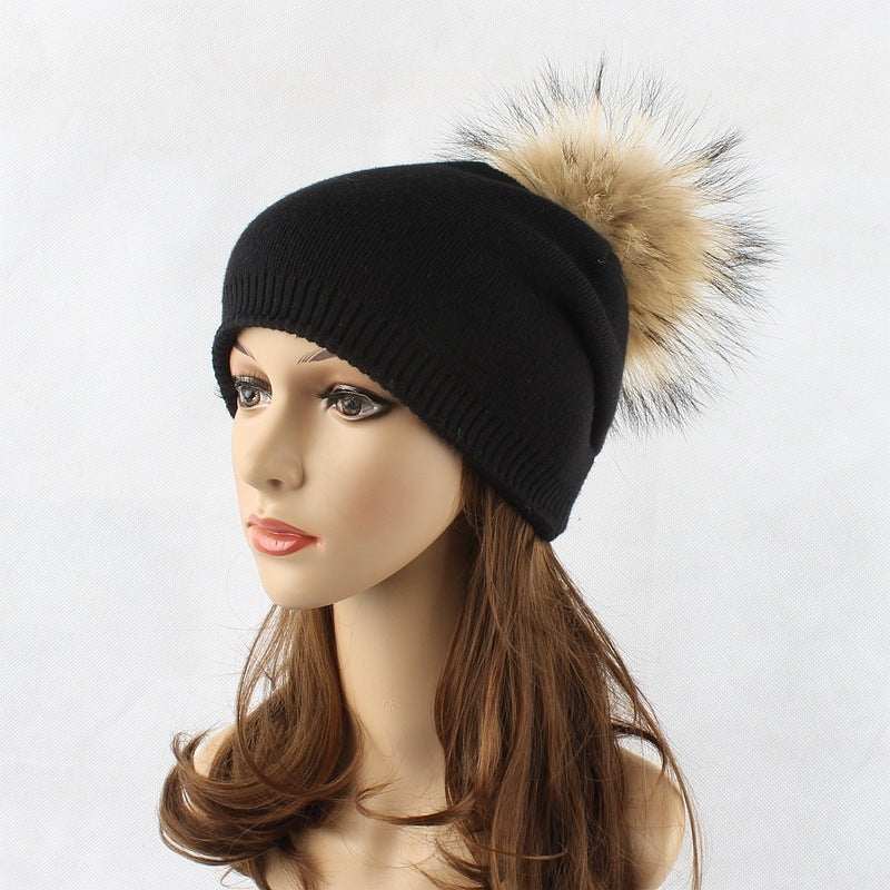 Winter black pompom beanie with raccoon fur detail, ideal for women.