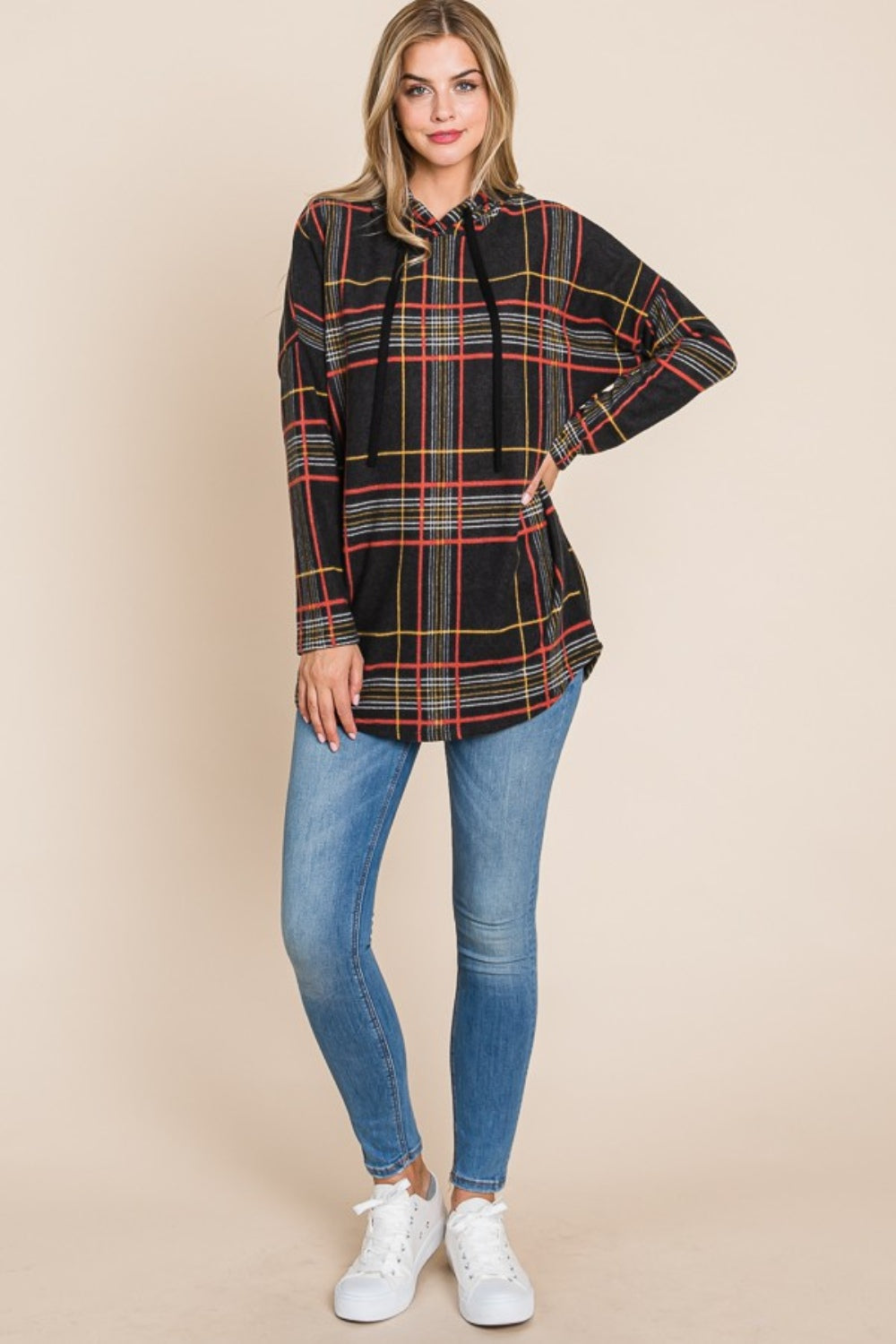 Plaid drawstring hoodie with long sleeves, worn by a model in jeans and sneakers.