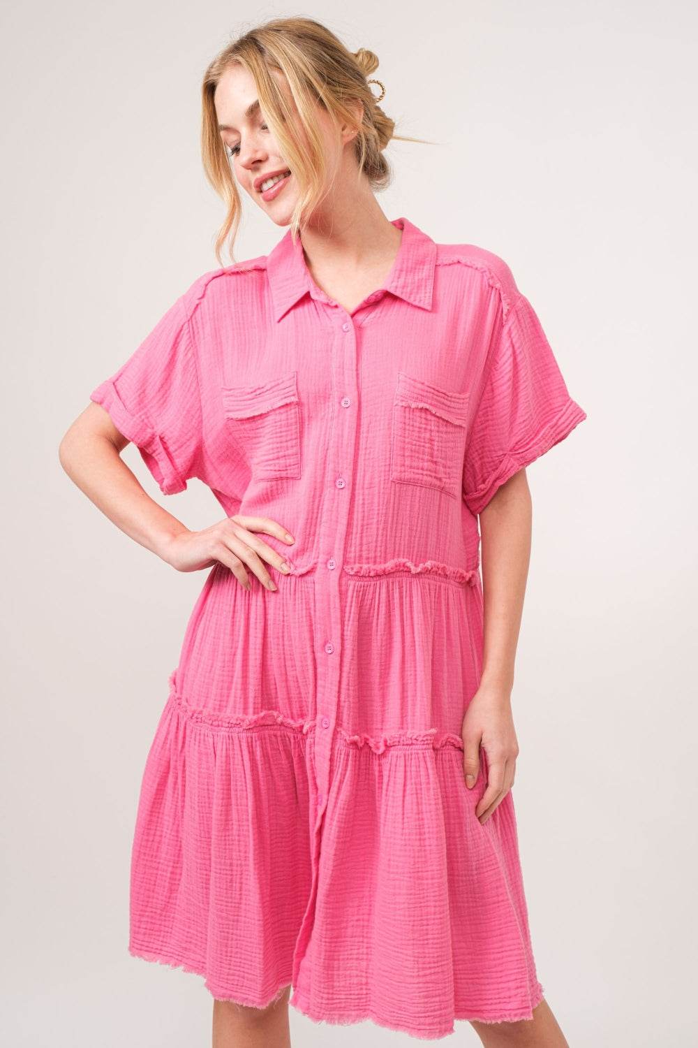 Pink raw edge tiered shirt dress with buttoned front and tiered design.