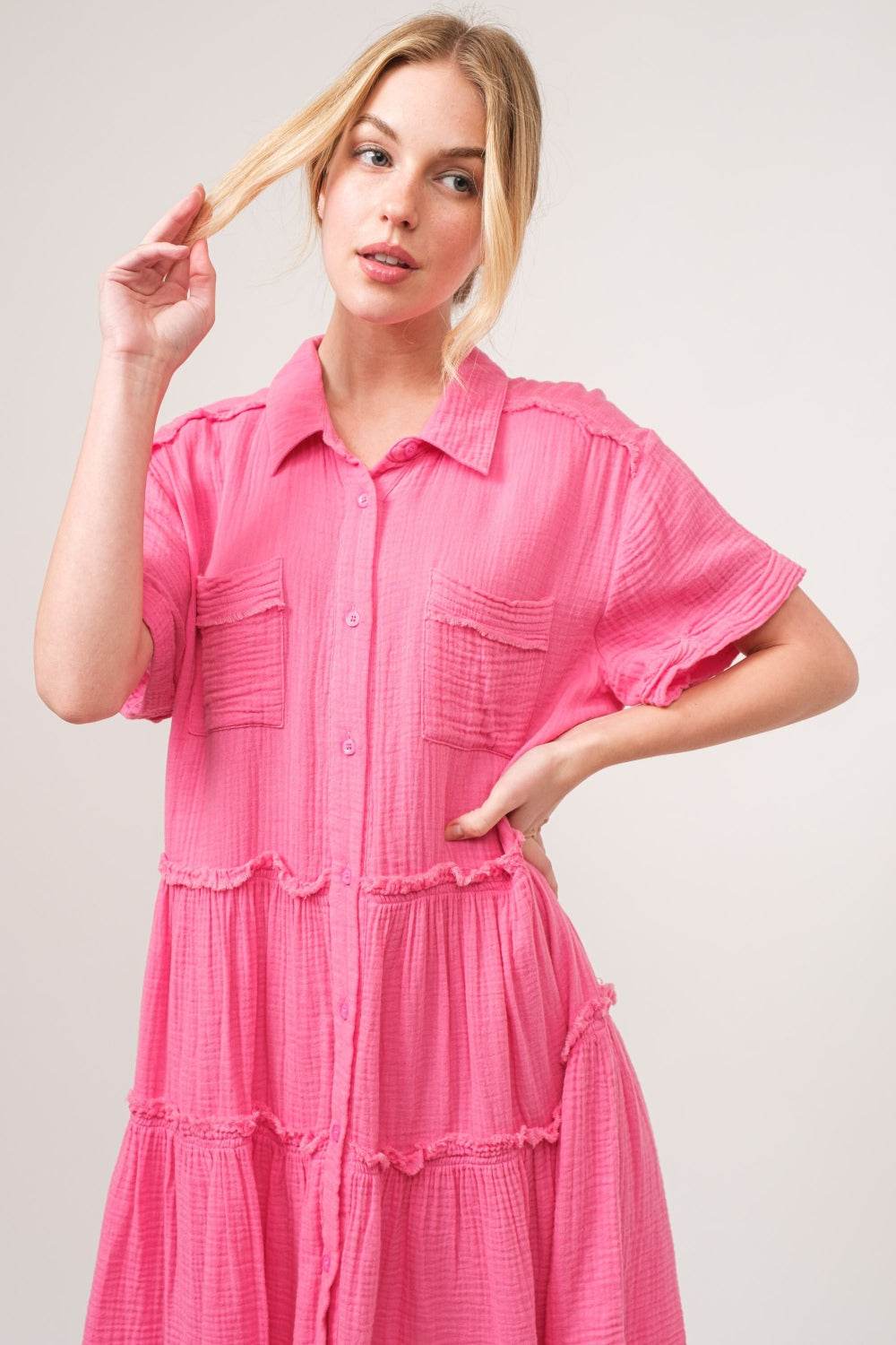 Raw edge tiered shirt dress in pink, featuring raw hems and a buttoned tiered design, made from 100% cotton.