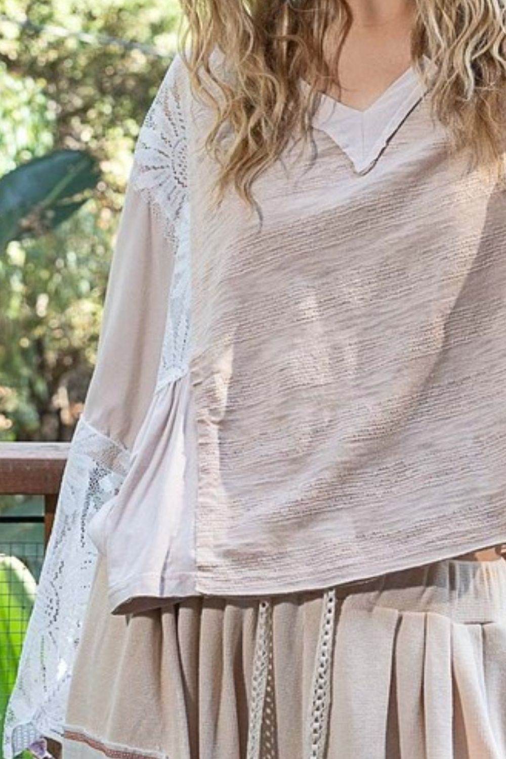 Lace detail V-neck flare sleeve blouse with lace accents and romantic design.