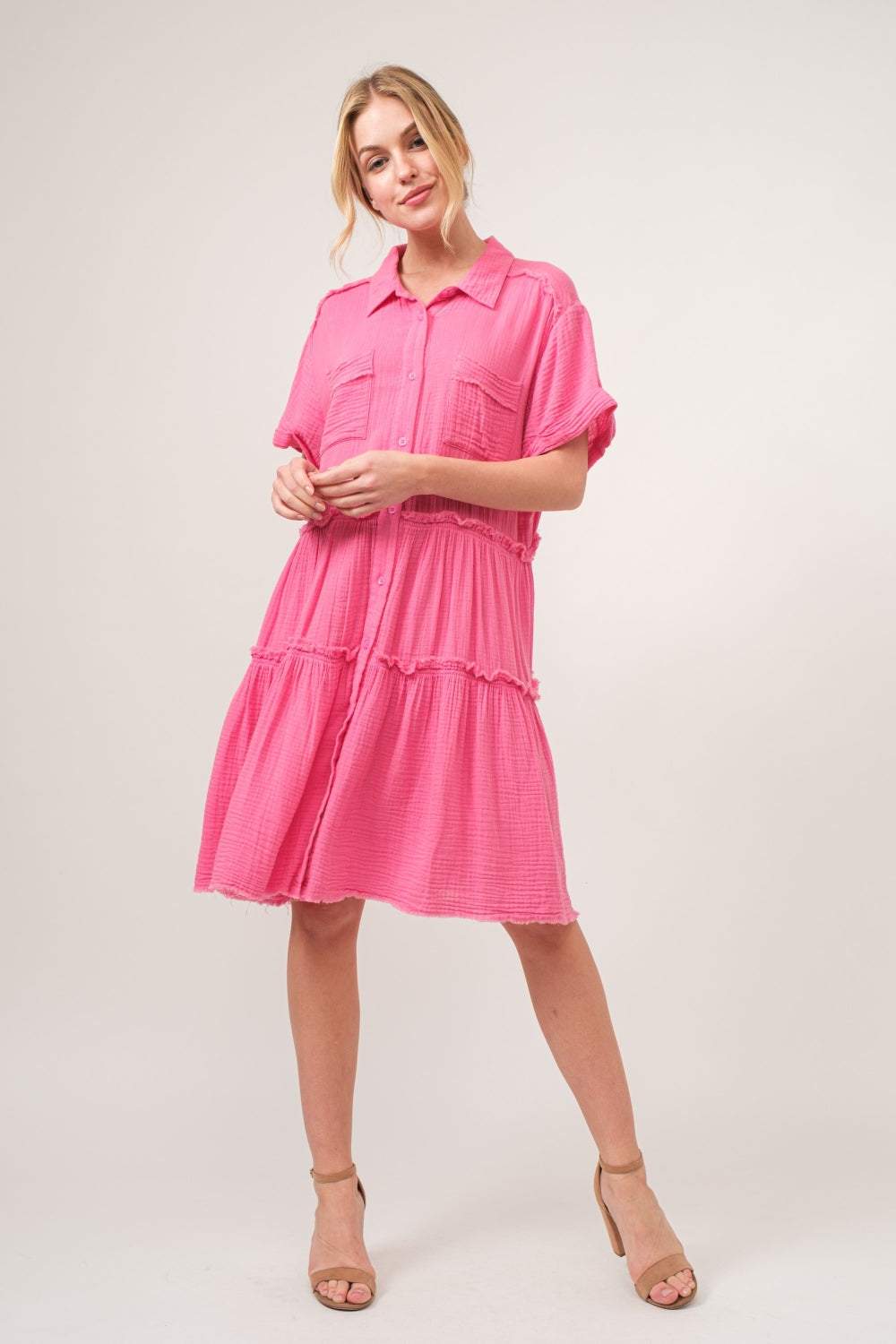 Raw edge tiered shirt dress in pink with button-up front and stylish tiered design.