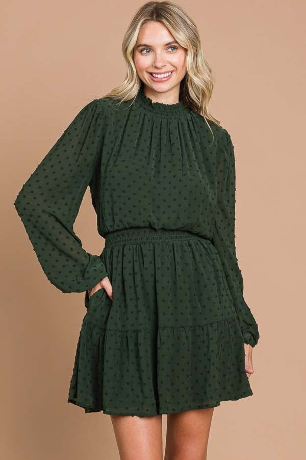 Swiss Dot Mini Dress with smock neck, long sleeves, and pockets in green.